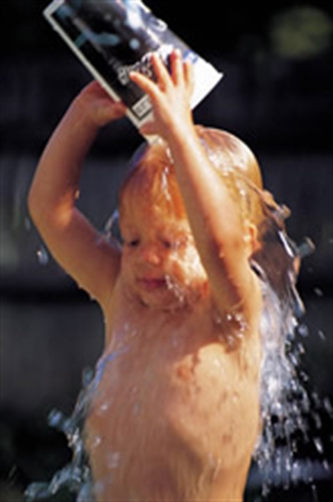 image of child pouring water over their head